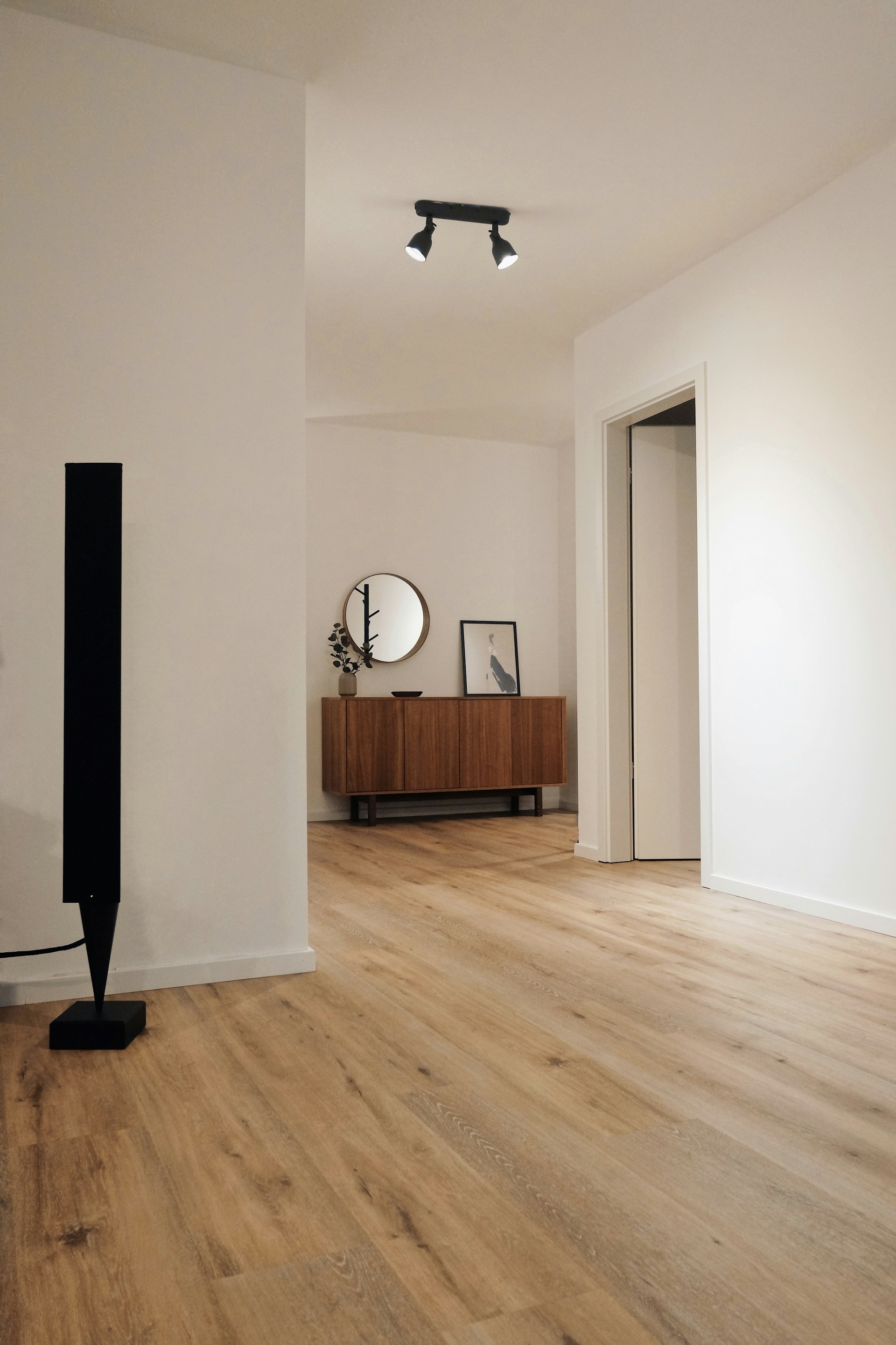 Modern home interior with wide-plank timber flooring and wooden sideboard